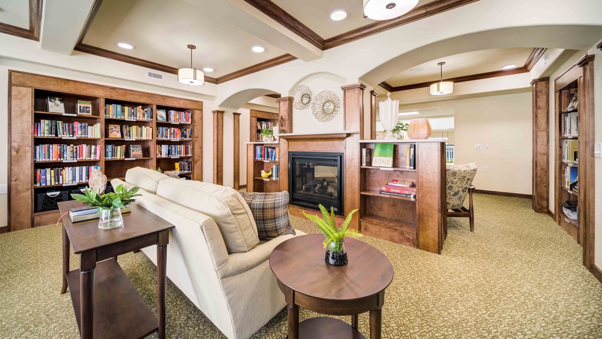 The library at Azalea Estates with shelves of books and comfortable seating